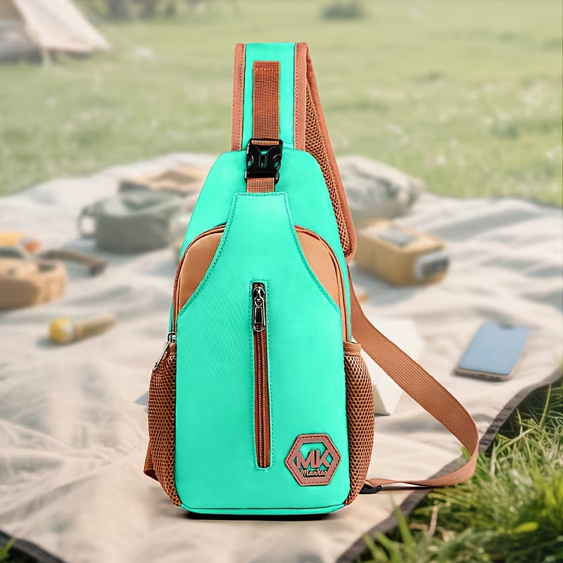 Mint green MK outdoor sling bag with tan mesh accents and front zip pocket on a picnic blanket