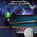 RGB gaming condenser microphone with green LED, pop filter, and tripod stand on a gaming desk